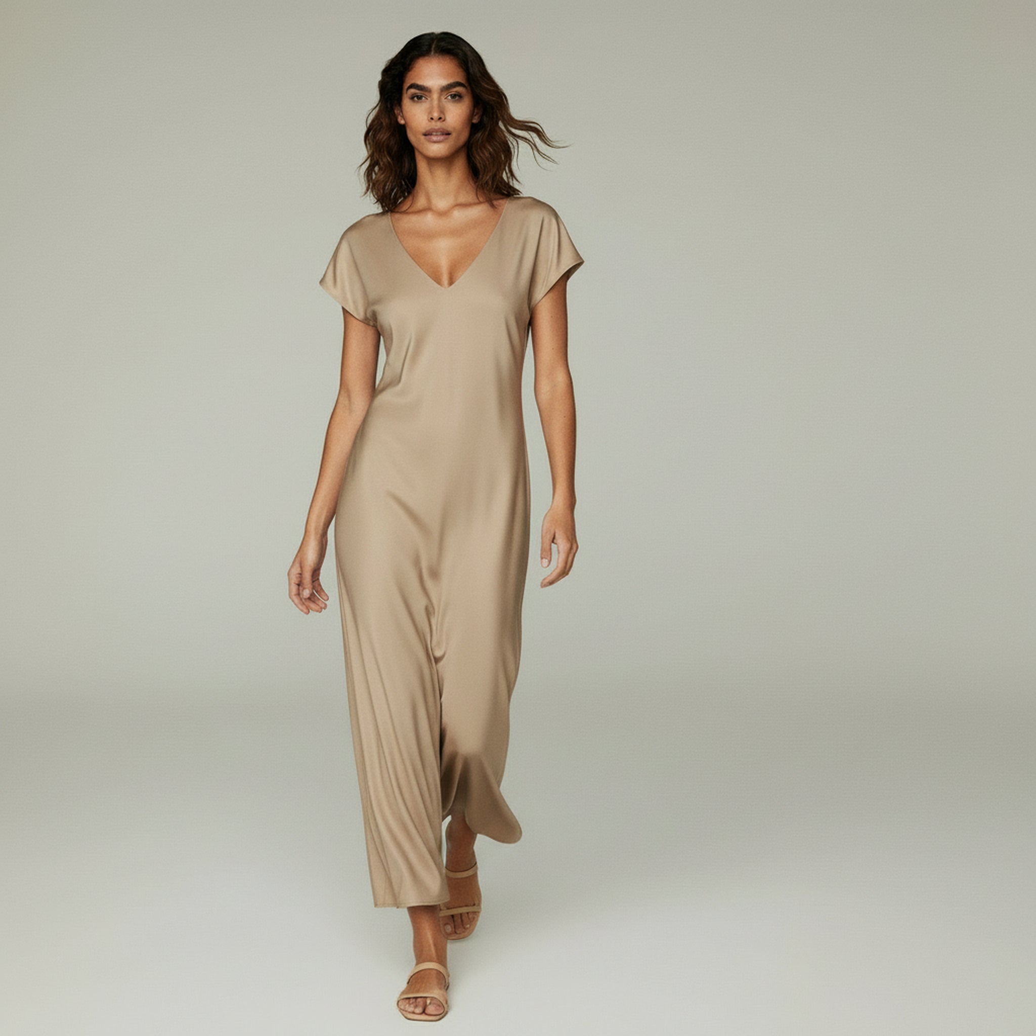 woman wearing beige midi cocktail dress on a plain bakcground