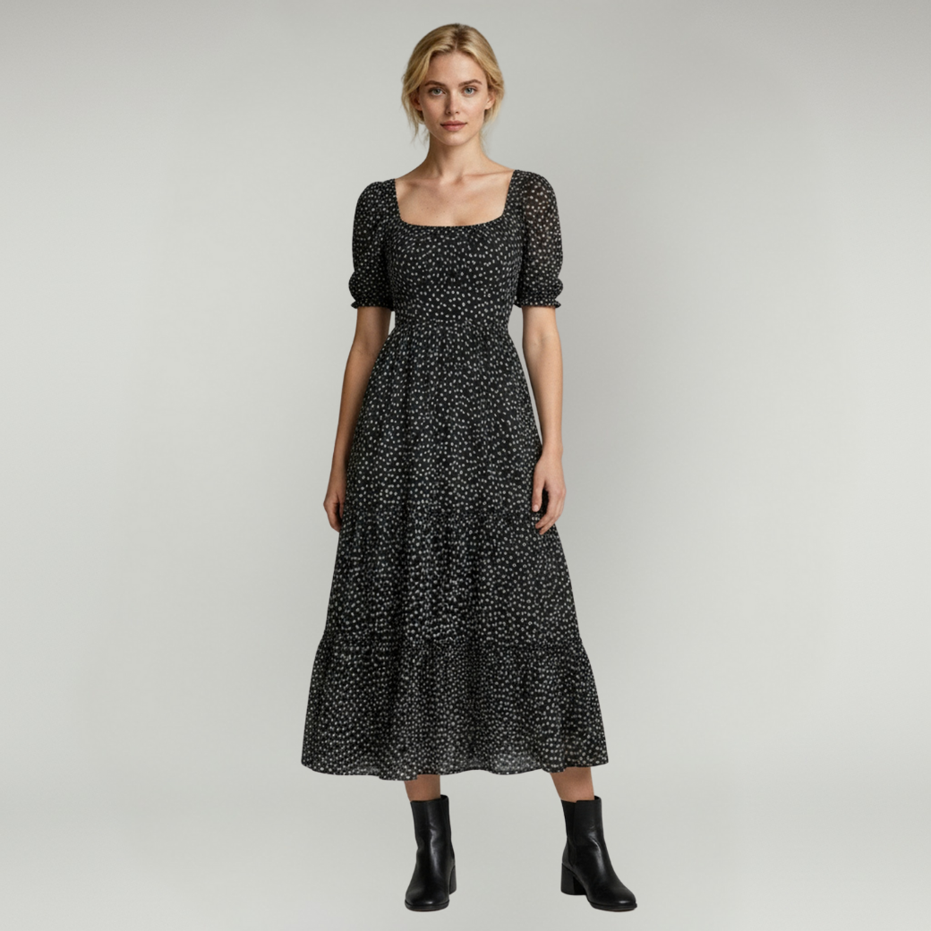 lady in black Maxi dress paired with black boots on a plain background