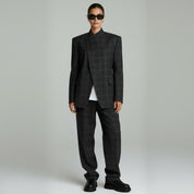 woman wearing black plaided blazer coat and pants on a plain background