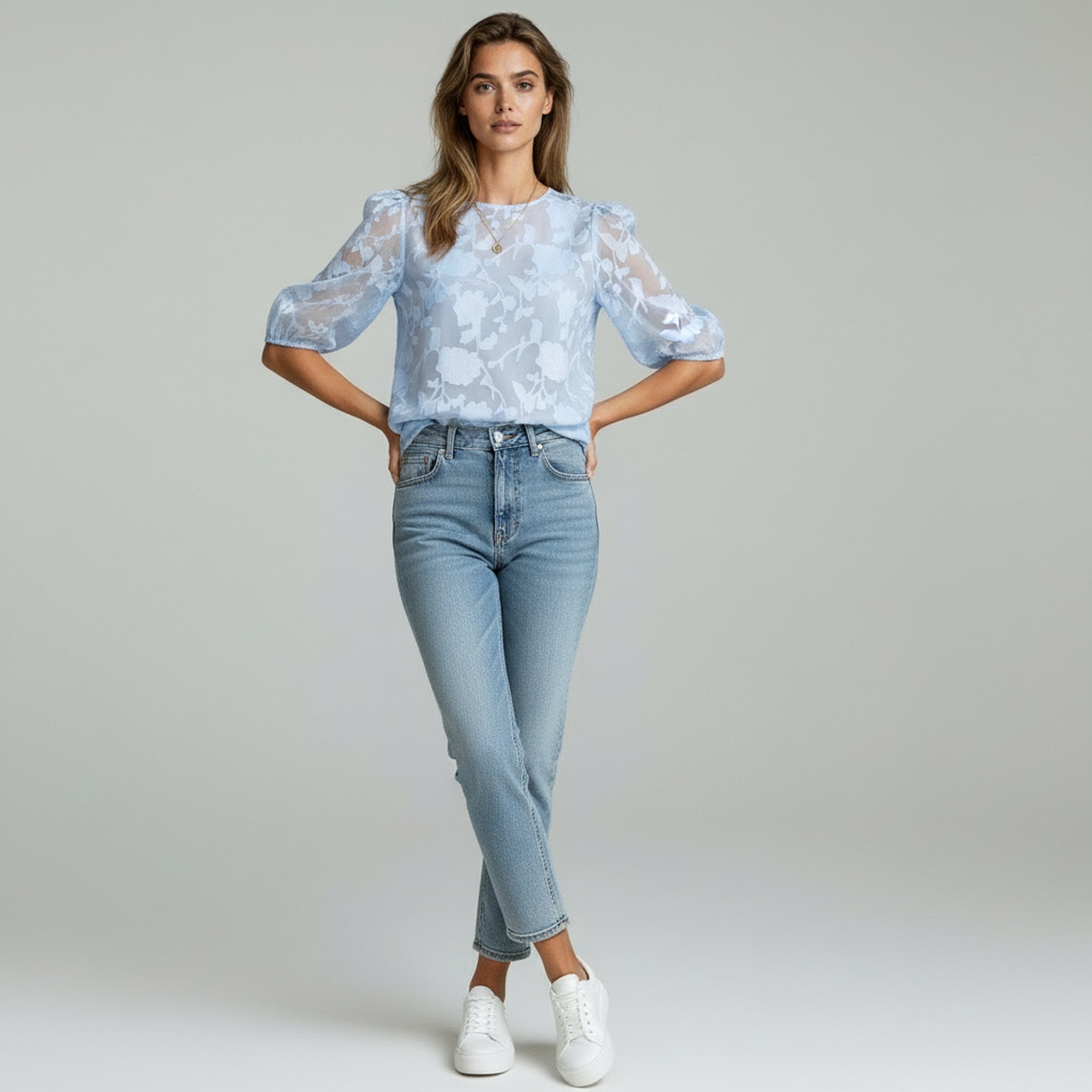 lady in blue top and blue jeans on a plain background