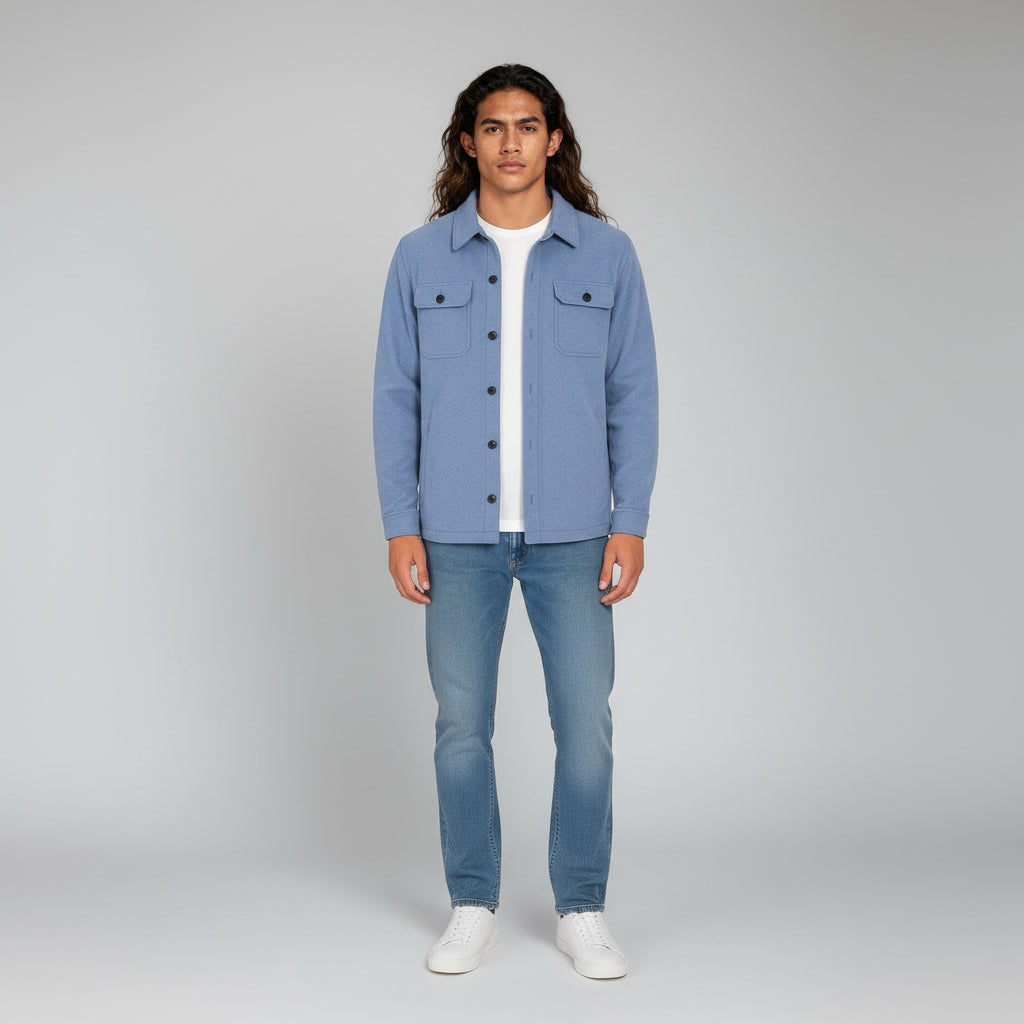 Man wearing a blue denim jacket and jeans on a gray background