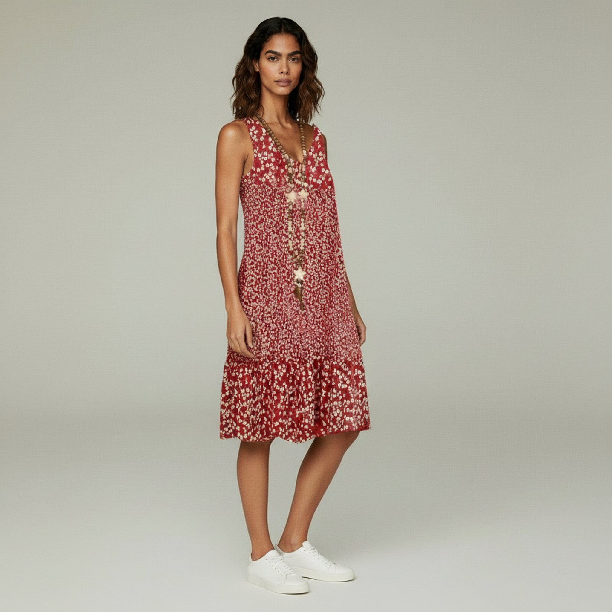 lady in red floral sleeveless dress on a plain background