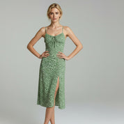 lady in green floral Sleeveless midi dress on a plain background