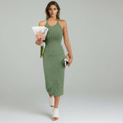 lady in green halter neck midi dress on a plain background