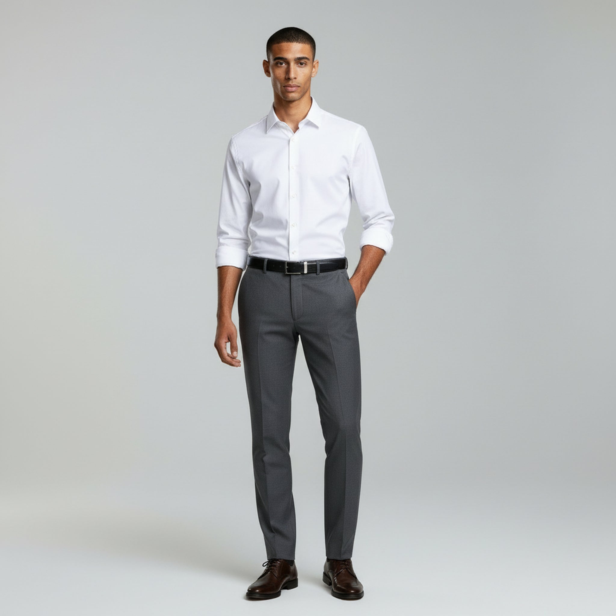 man wearing white long sleeve polo and grey pants on a plain background