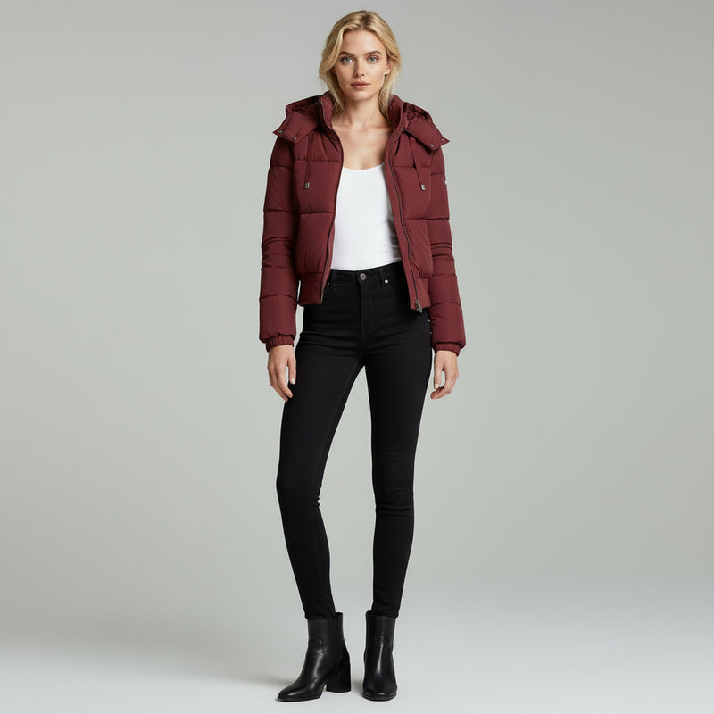 woman wearing white inner top with hooded jacket paired with black pants on a plain background
