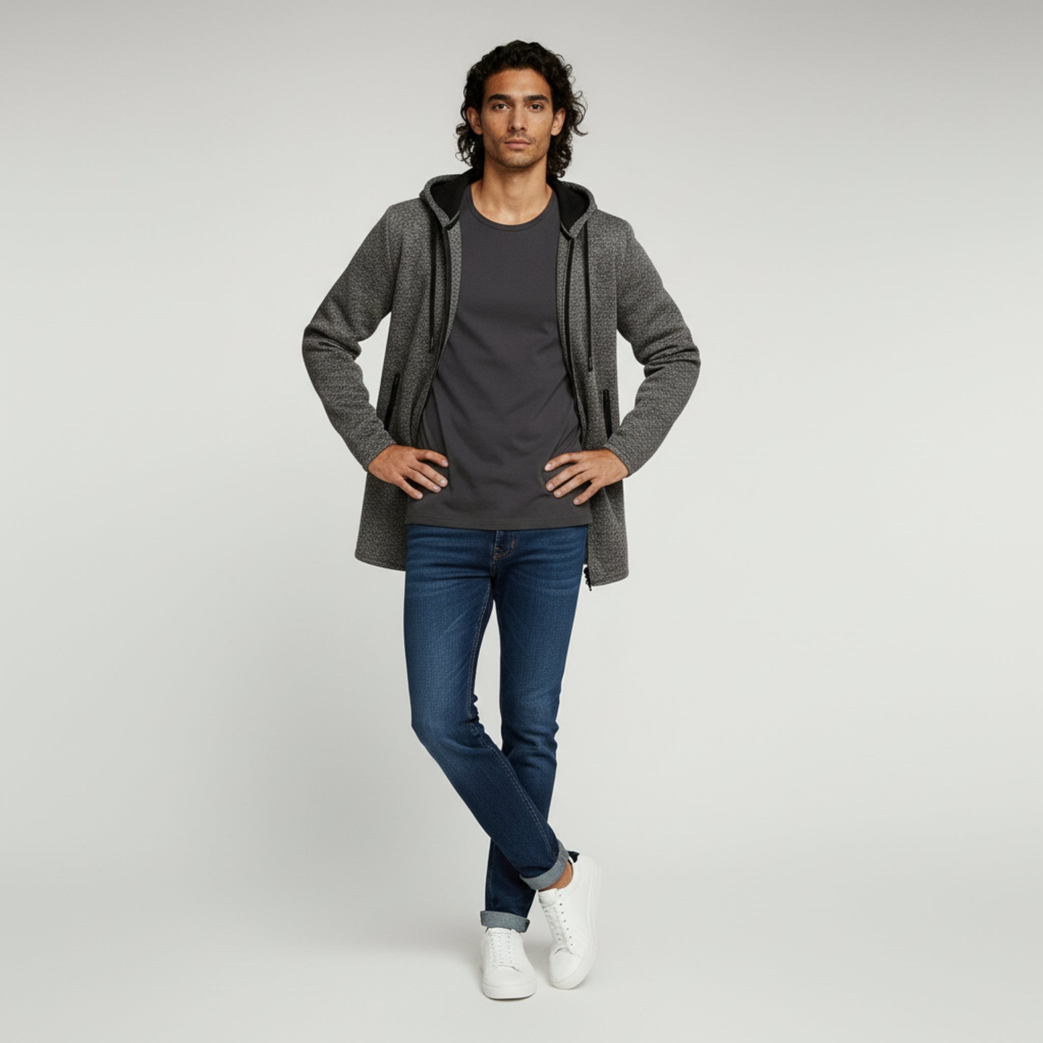 man wearing hoodie long jacket and pants on a plain background