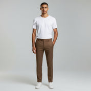 man wearing white shirt top paired with khaki pants on a plain background