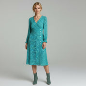 woman wearing light blue long sleeve mini dress paired with green shoes on a plain background