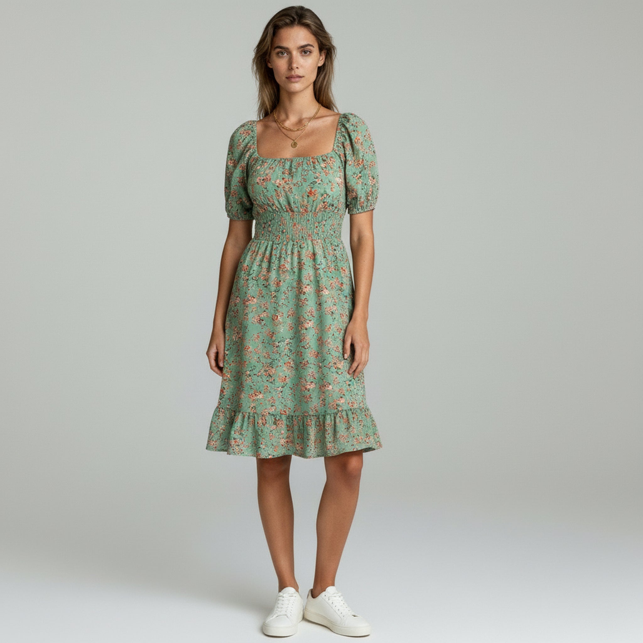 Woman wearing light-green flowy maxi dress on a plain background