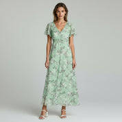 woman wearing green maxi dress on a plain background