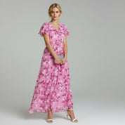 lady in pink maxi dress on a plain background