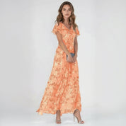 woman wearing orange maxi dress on a plain background