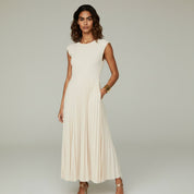 lady in white sleeveless maxi dress on a plain background