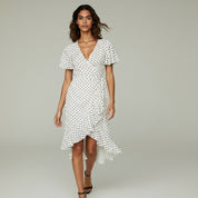 woman wearing white maxi dress on a plain background