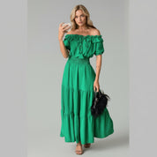lady in green off-shoulder maxi dress on a plain background