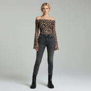 lady wearing off shoulder leopard print top and pants on a plain background