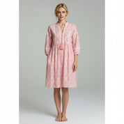 woman wearing light pink summer dress on a plain background