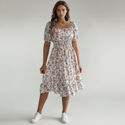 lady in white floral maxi dress on a plain background