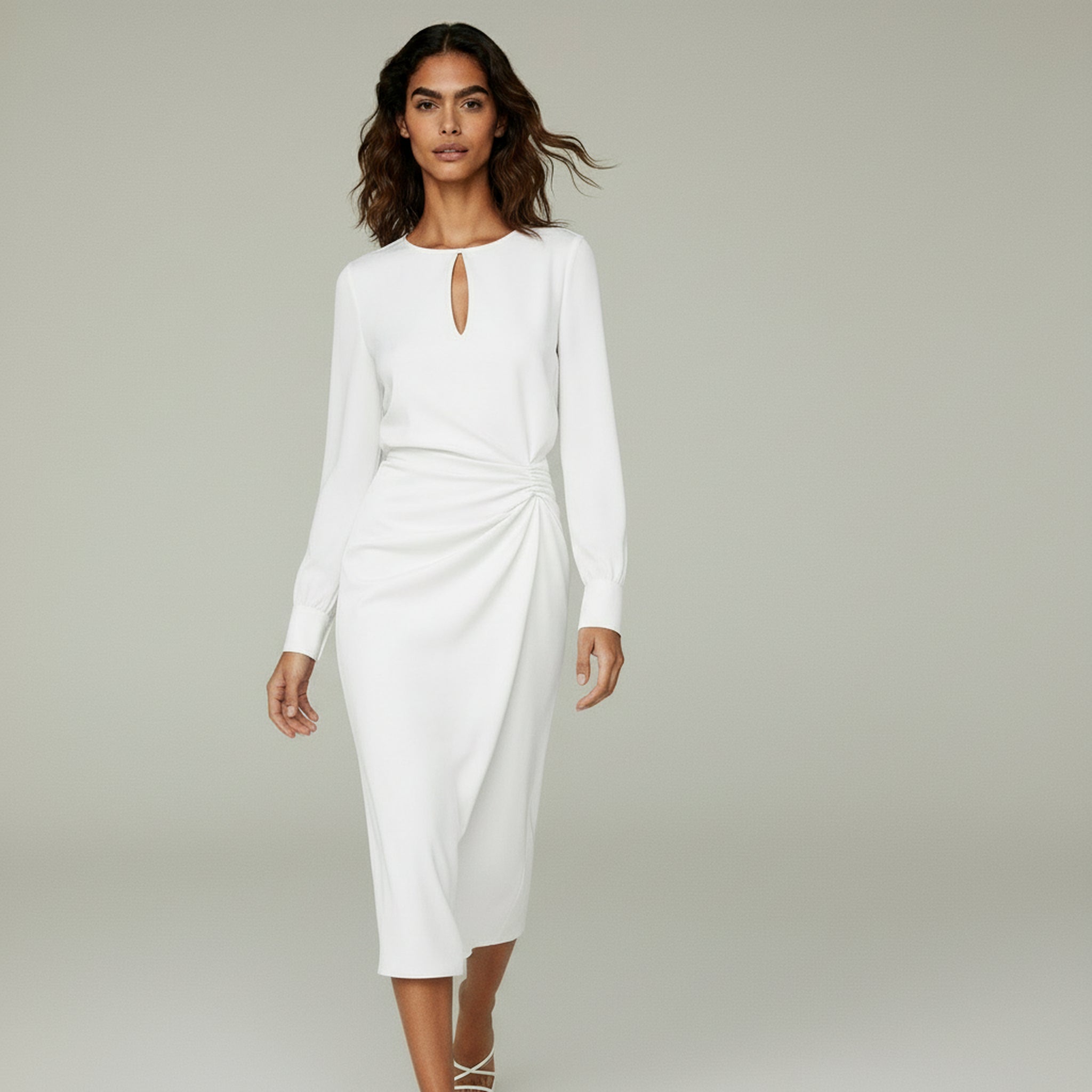 woman wearing white long sleeve formal maxi dress on a plain background