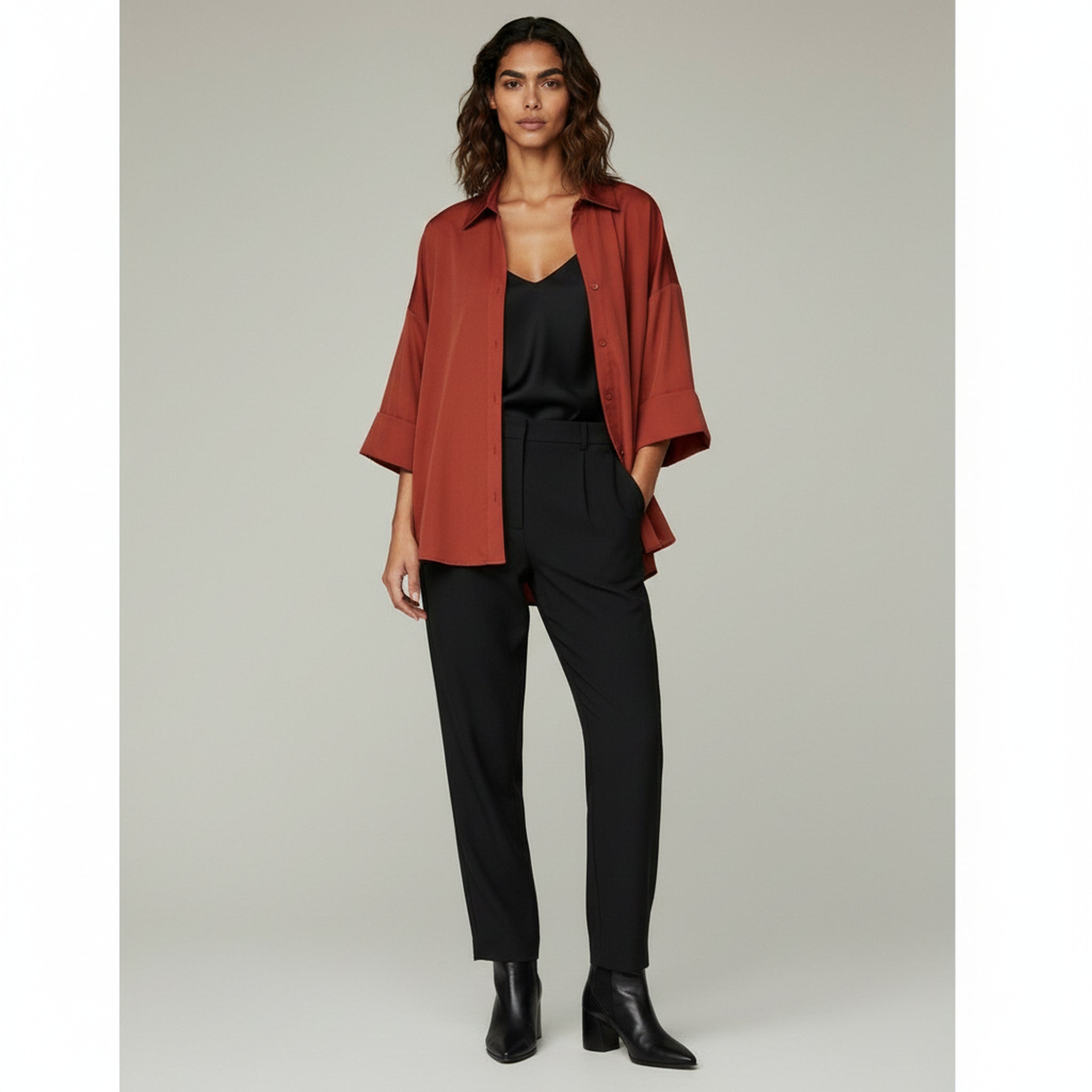 lady wearing black inner top and red loose collar shirt paired with black pants on a plain background