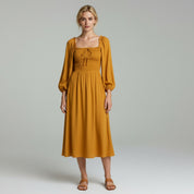 lady in yellow maxi dress on a plain background