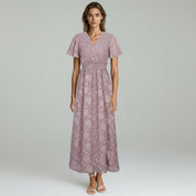 woman wearing purple maxi dress on a plain background