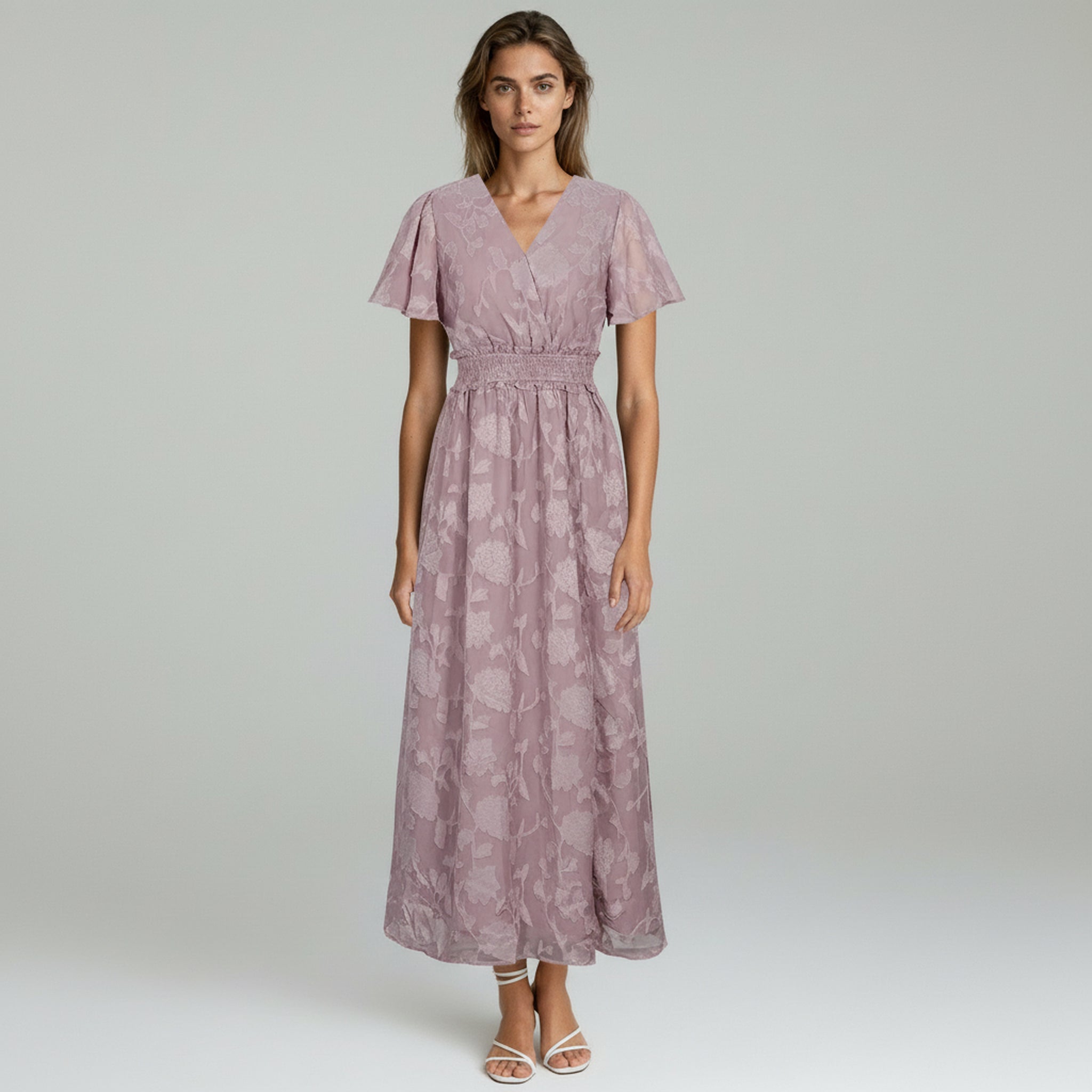 woman wearing purple maxi dress on a plain background