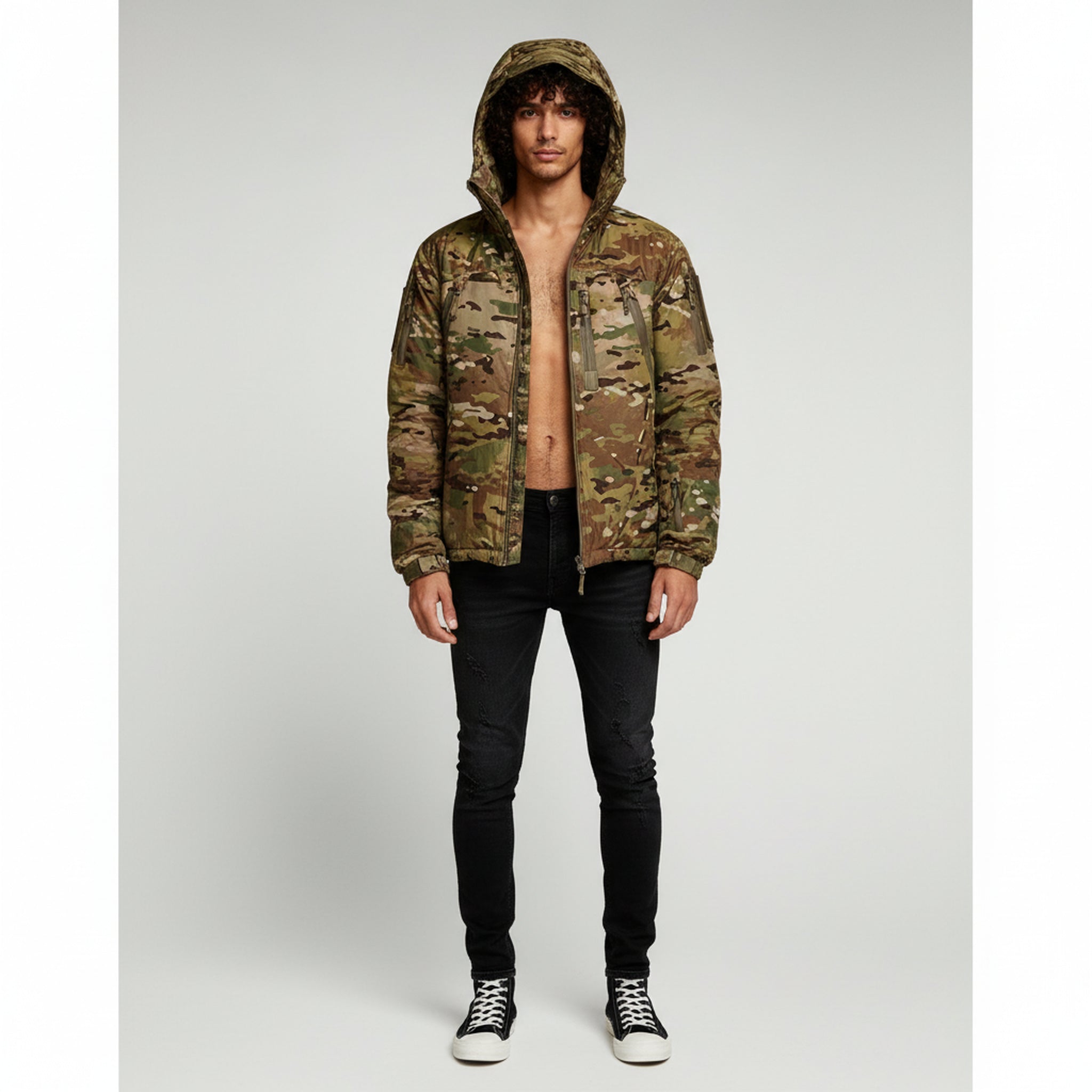 man wearing hooded jacket and black pants on a plain background