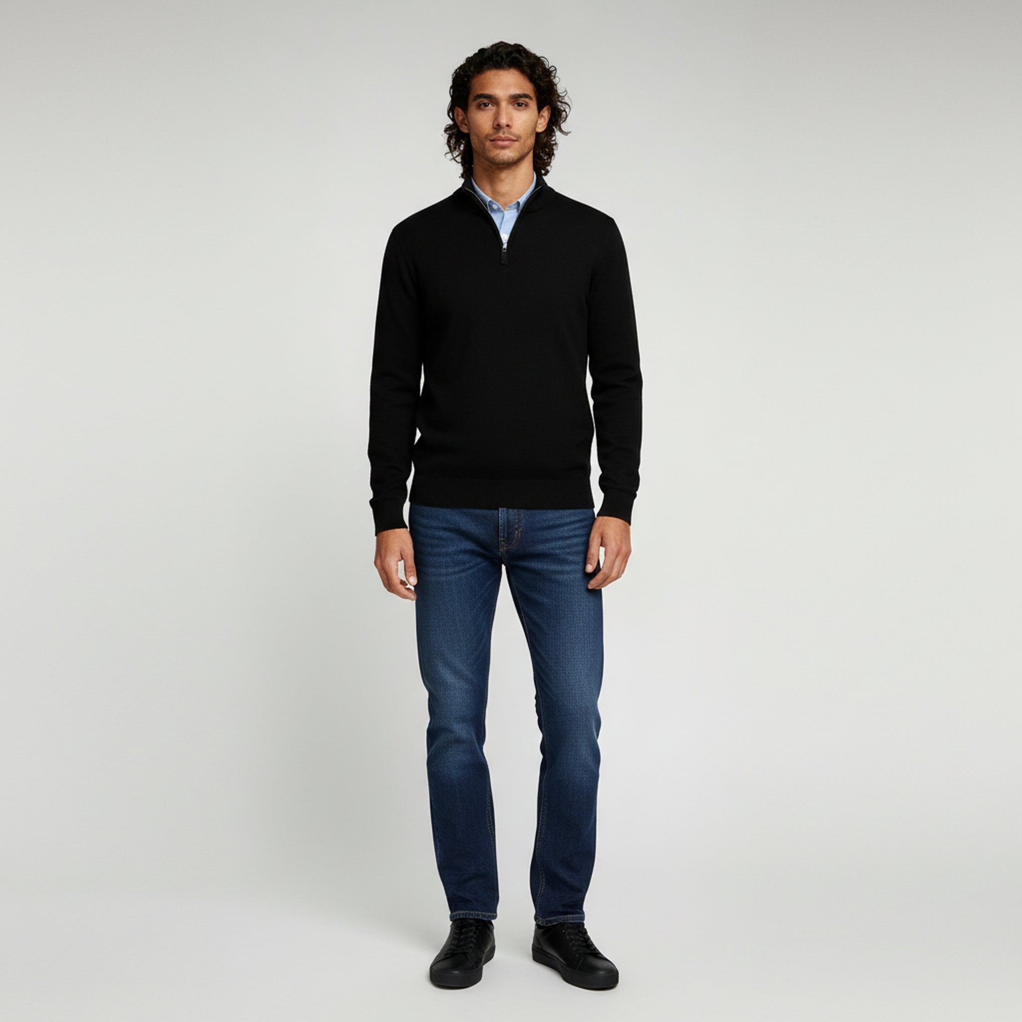 man in black sweater and pants on a plain background